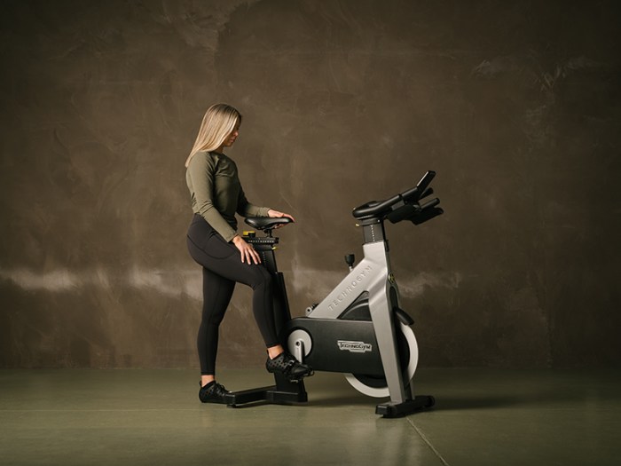 A wellness instructor climbing on a stationary bike in the gym at Gleneagles Townhouse