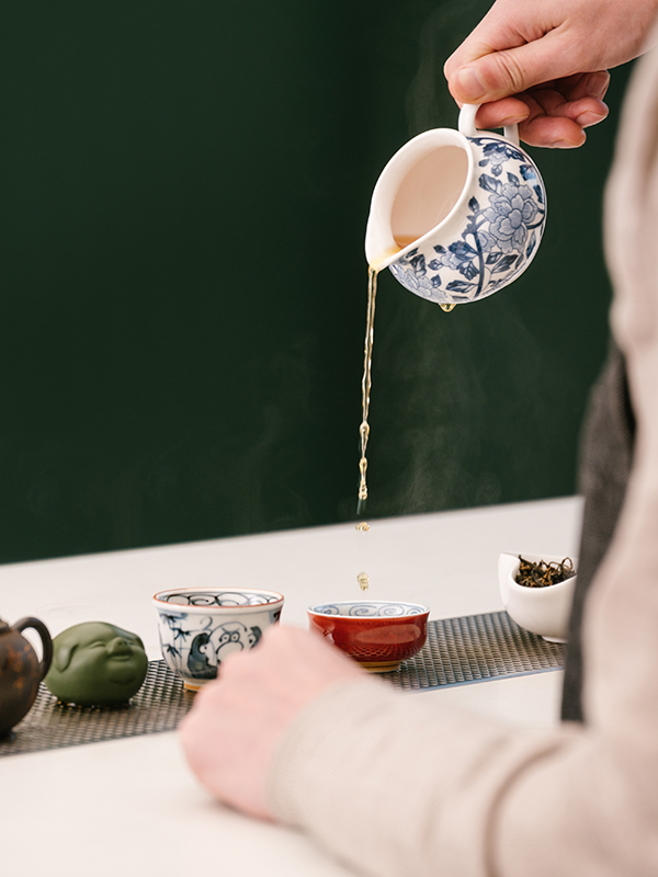 Pouring tea in a tea cup from a tea pot