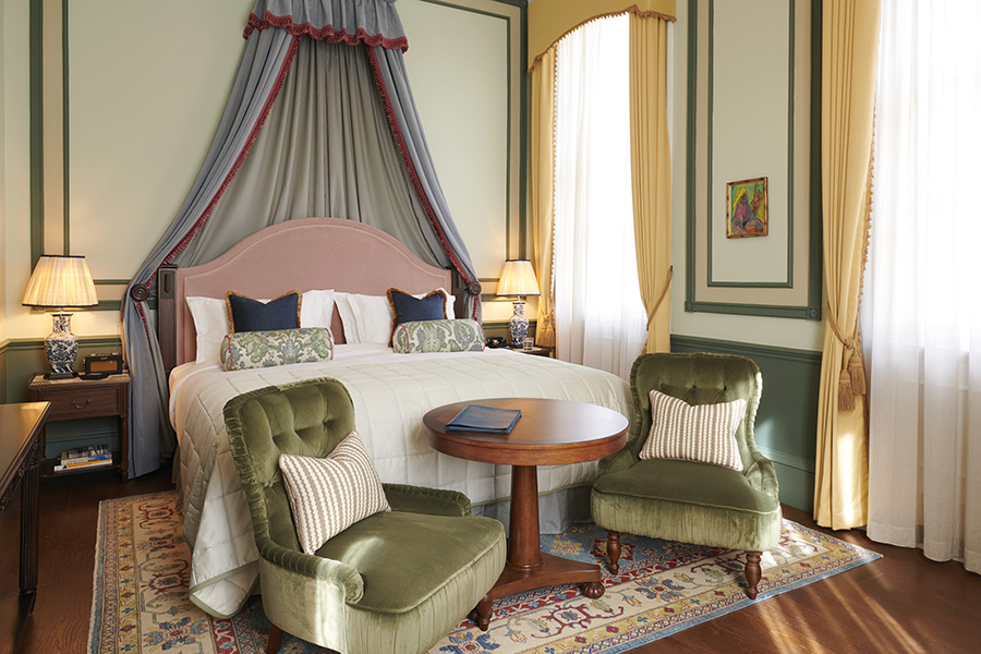 A Town Bedroom at Gleneagles Townhouse with green velvet chairs, large bed and windows