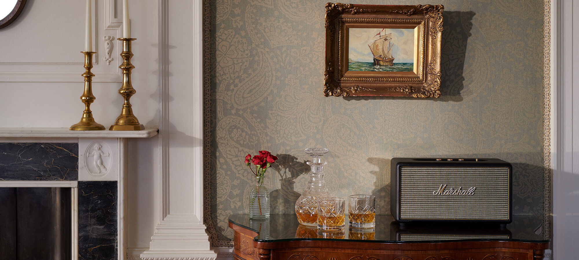 Two crystal glasses and decanter filled with whisky sit on a side table next to a vintage styled digital radio in the Royal Lochnagar Suite