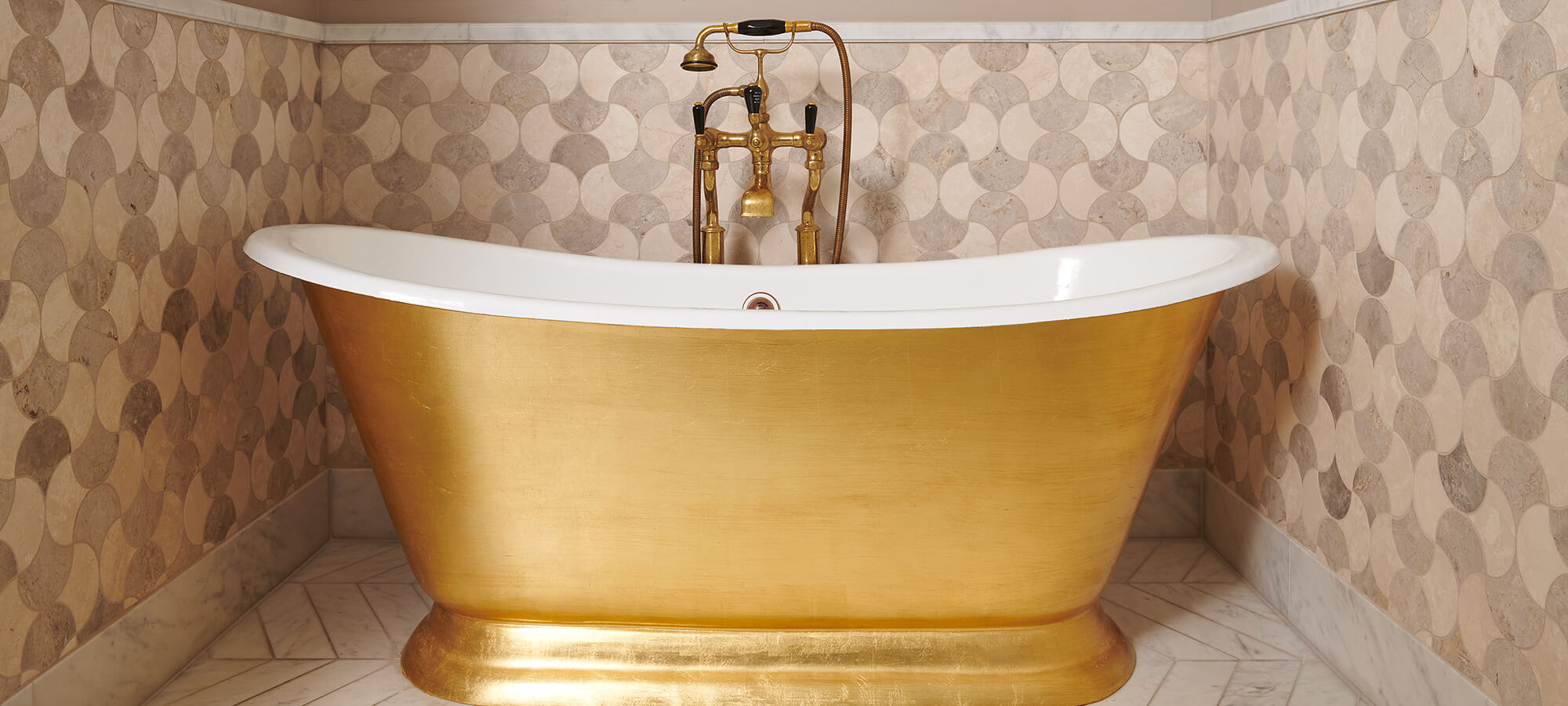 A large gold roll top bath in an estate suite