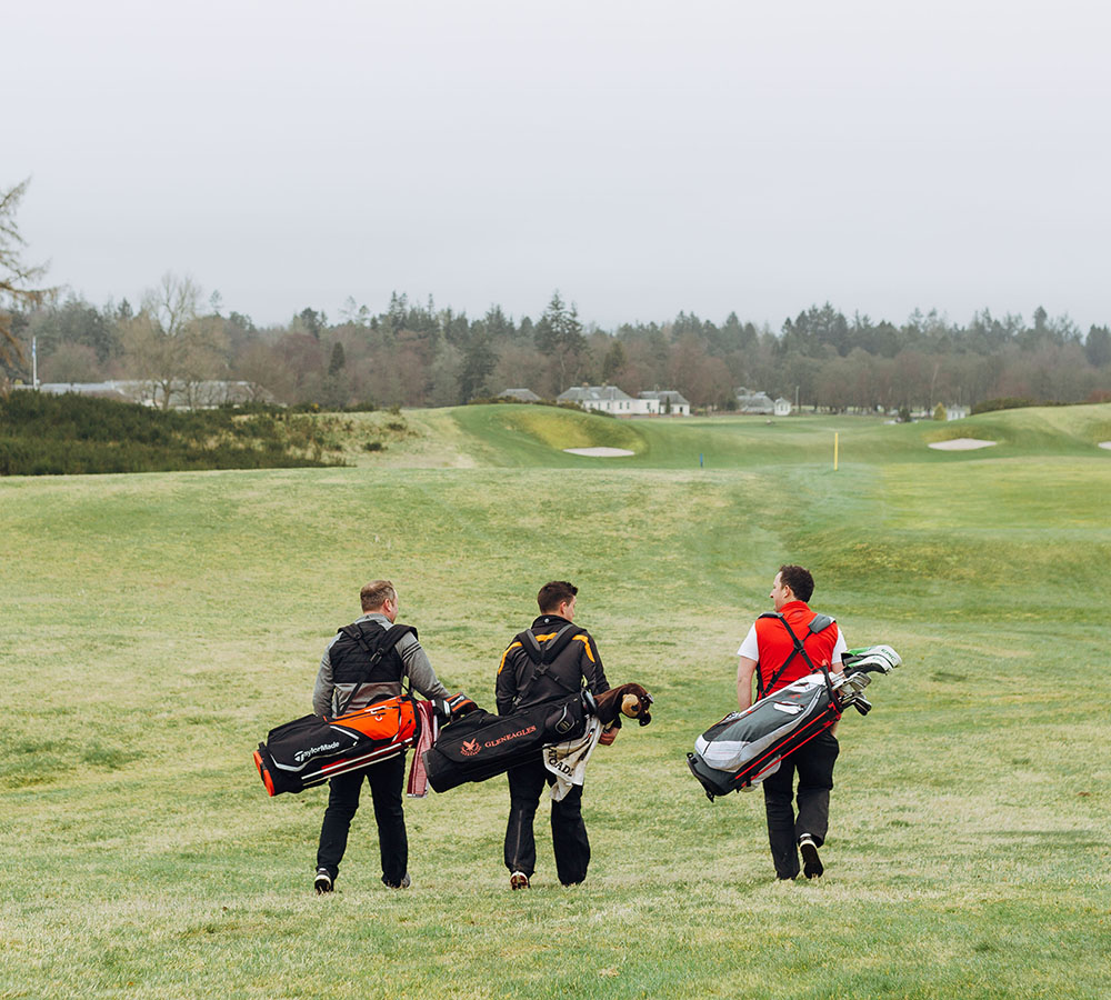 Trois golfeurs marchant sur un fairway au printemps au Gleneagles.