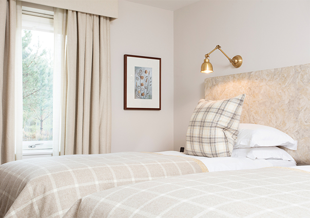 a bright bedroom with two single beds with checked bed sheets