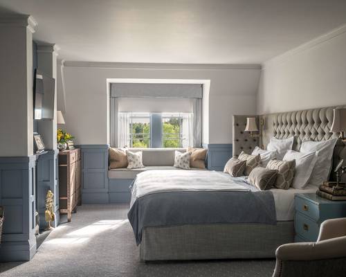 A side on view of a large double bed with blue sheets