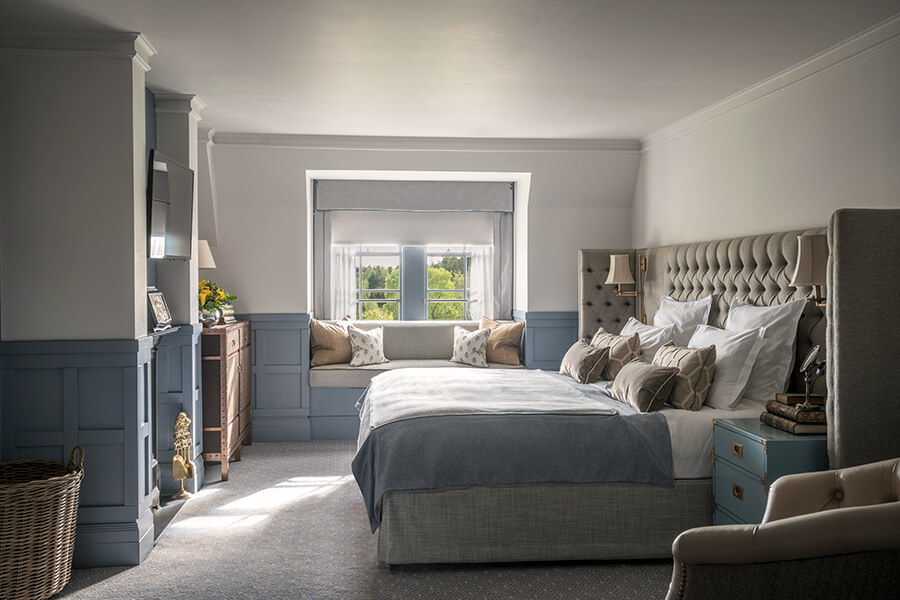 A side on view of a large double bed with blue sheets