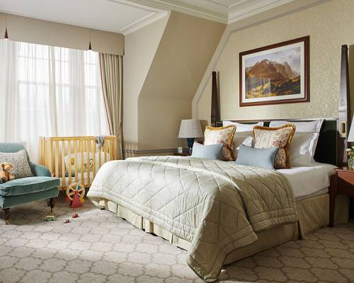 A large bedroom with cot and child's toys