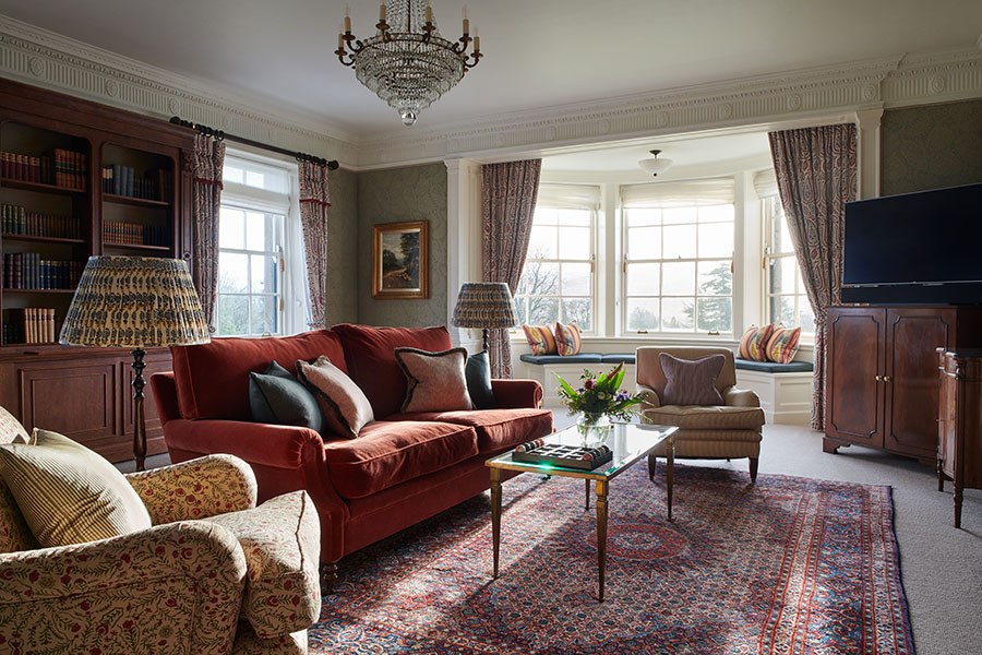 The living room in the Royal Suite with large seating area, book cases and seating in a bay window
