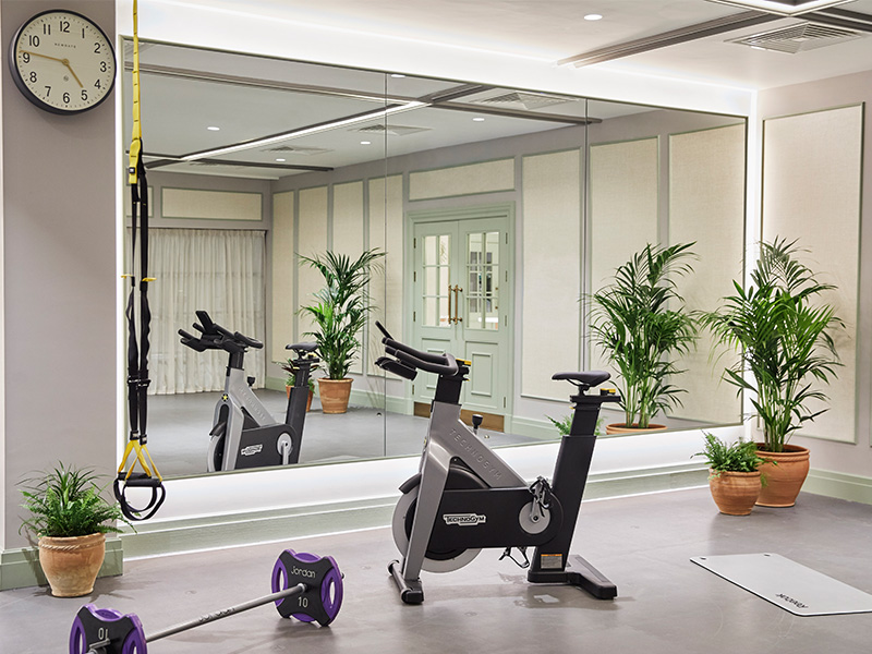 A spin bike and barbell in front of a mirror in the studio