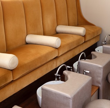 Yellow suede sofas sit above pedicure stations