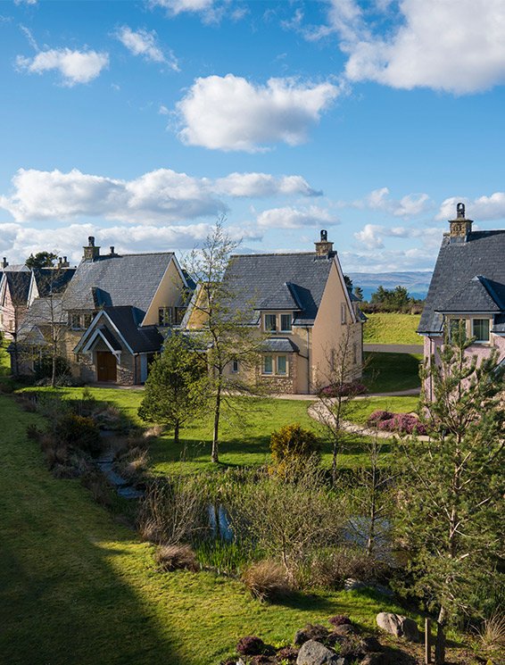 Les lodges Glenmor entourés d'herbe et d'arbres