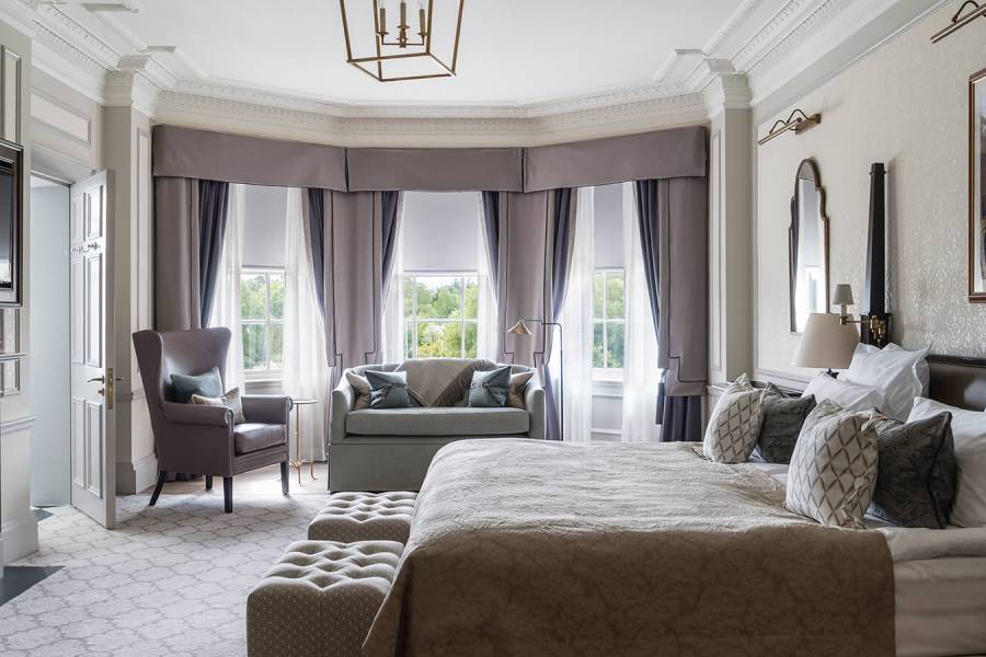 A large Estate bedroom with bay window, king sized bed and ample seating