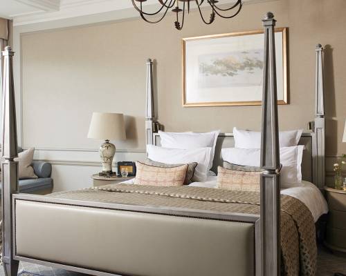 A large four-poster bed in a beige coloured room in an estate suite
