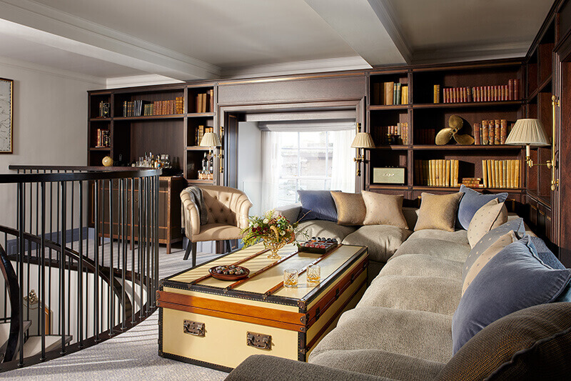 A large sitting room with grey sofa surrounding a chest ottoman