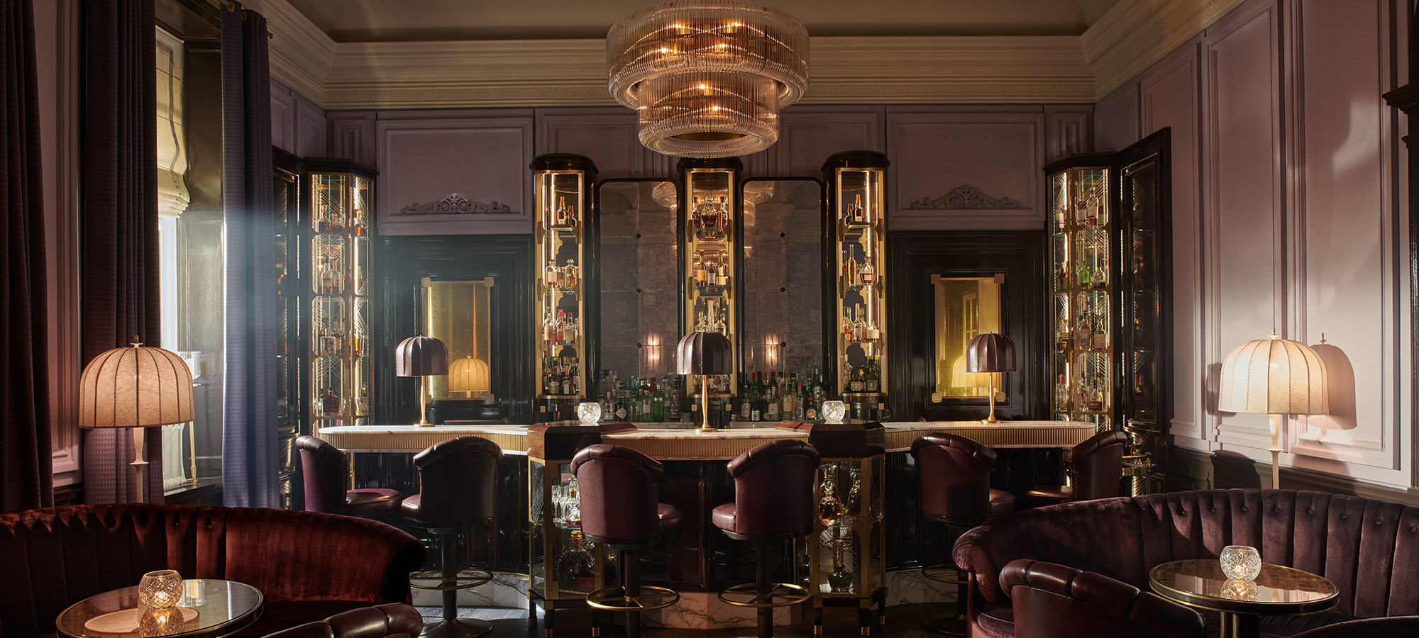 Light spills through an open curtain into the 1920s inspired American Bar