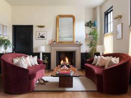 Two large red sofas surround a fire and coffee table in the waiting area