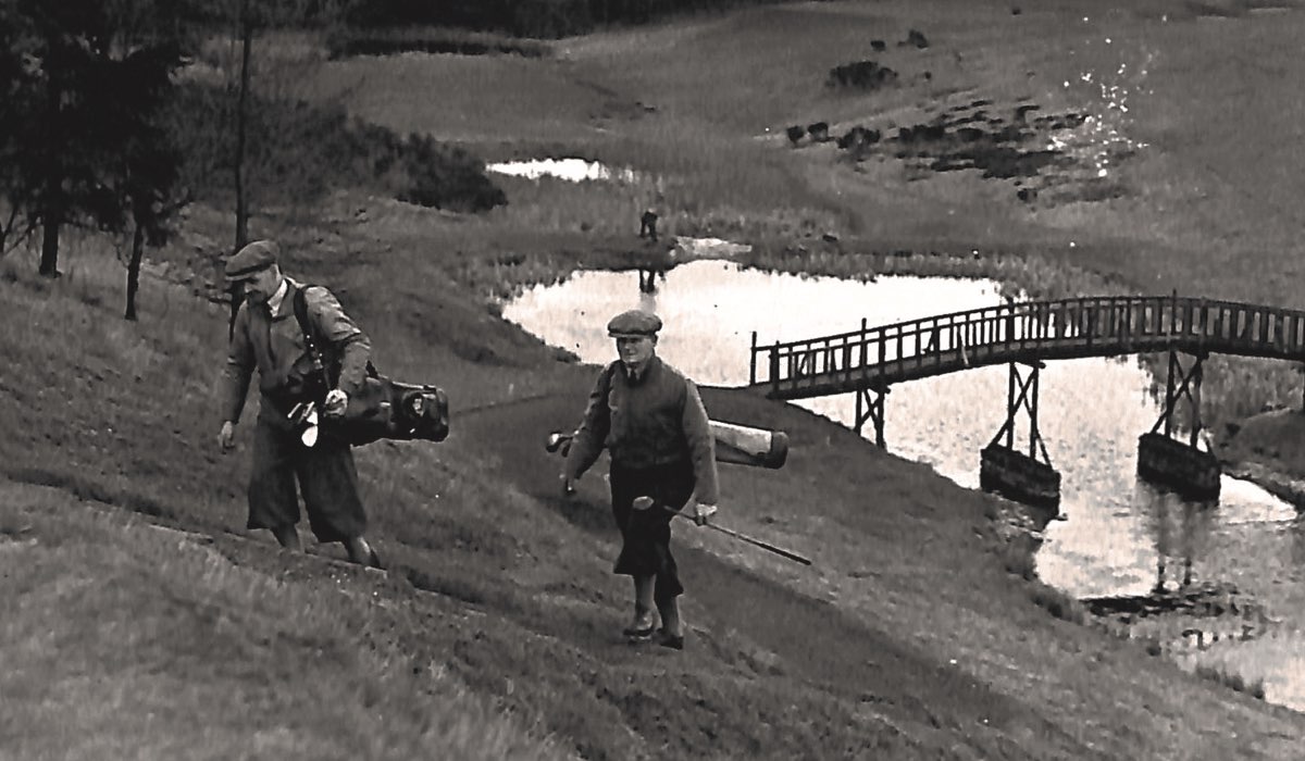 A black and white vintage photo shows two golfers playing the Queen's course at Gleneagles