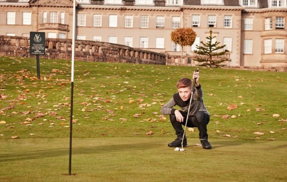 A boy lines up his put on a green at Gleneagles