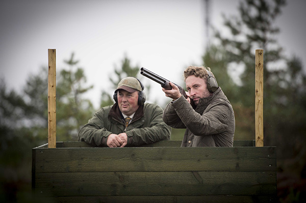 An instructor shows a man how to shoot on the range at Gleneagles