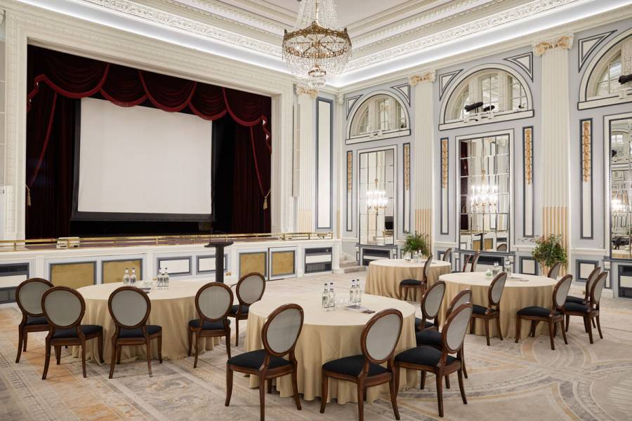 The ballroom set for a presentation with cabaret tables, projector and screen