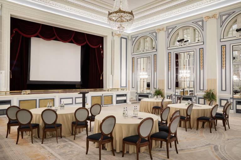 The ballroom set for a presentation with cabaret tables, projector and screen