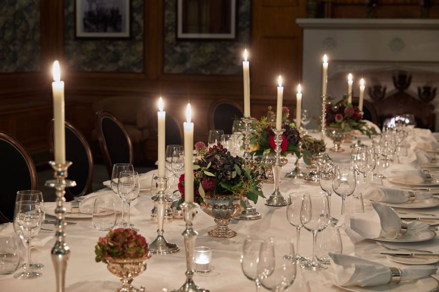 A candle lit silver service on a large table in the billiard room