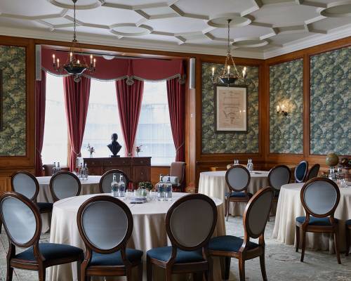 The billiard room set cabaret style with water and notepads on the tables