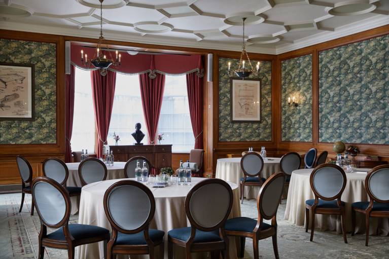 The billiard room set cabaret style with water and notepads on the tables