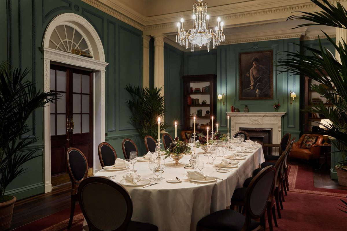 The parlour set for a candlelit banquet