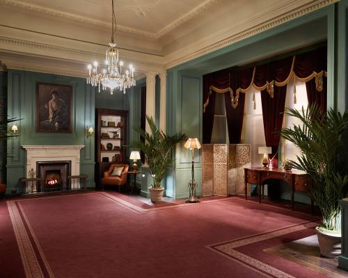 Red carpet, green walls, tow fireplaces and numerous antiquities in the Parlour room at Gleneagles