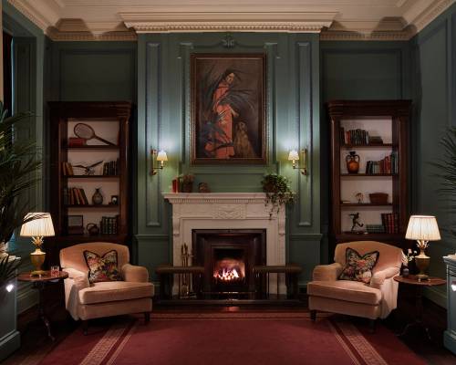 Two arm chairs sit next to an open fire in the ornate parlour room at Gleneagles