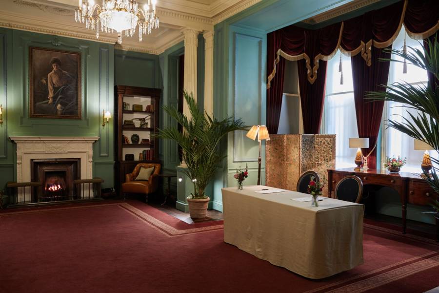 A wide shot of a table set up for a private checkin in the parlour room at gleneagles
