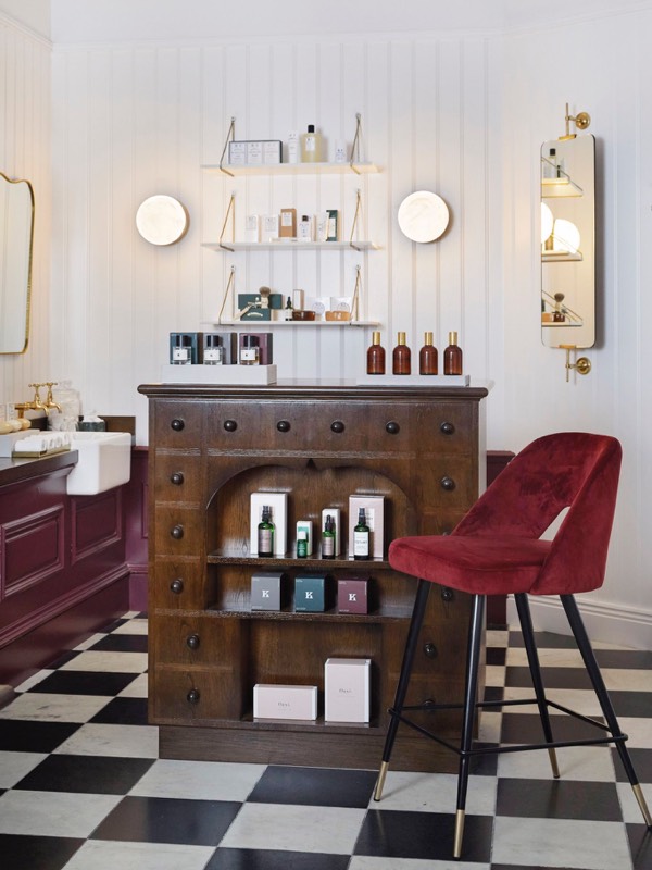 A red chair next to a cabinet with beauty products in the Gleneagles arcade