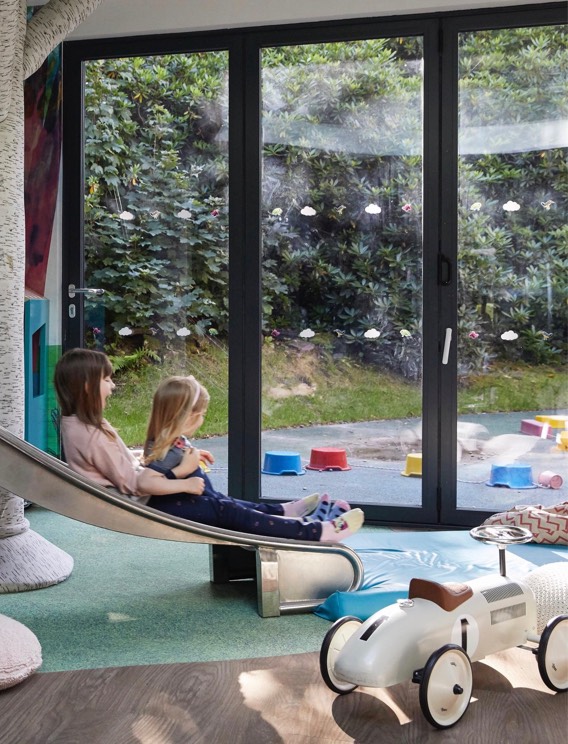 Two girls slide down the slide in Little Glen