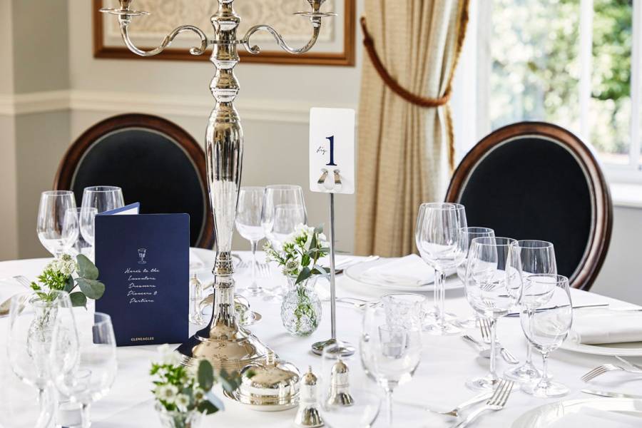 A table laid for silver service with silver candelabra in the drawing room