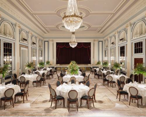 The gleneagles ballroom set up with around tables of 10 for dinner with large floral arrangements and grand chandeliers