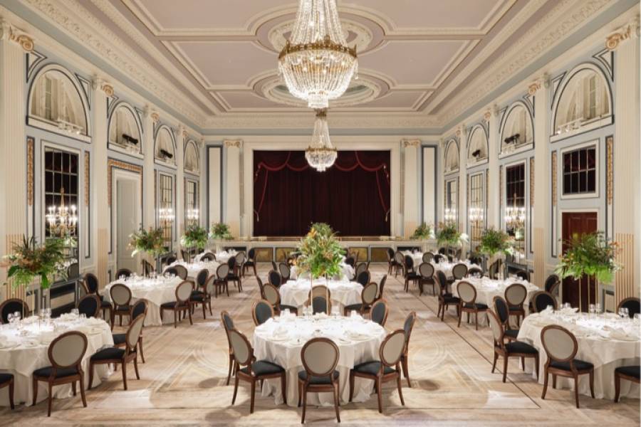 The gleneagles ballroom set up with around tables of 10 for dinner with large floral arrangements and grand chandeliers