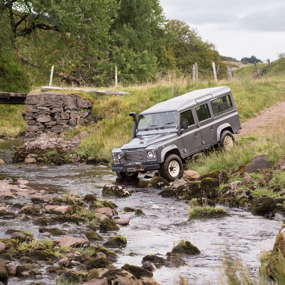 a Land Rover defender approaches entry to a river