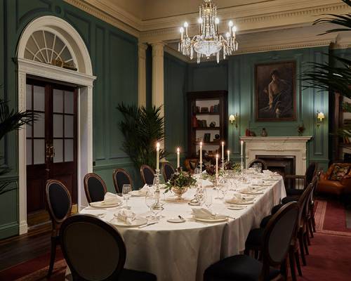 The parlour room set up for a silver service candlelit dinner for fourteen