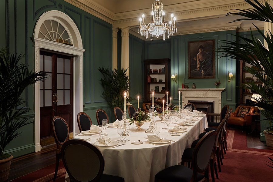 The parlour room set up for a silver service candlelit dinner for fourteen