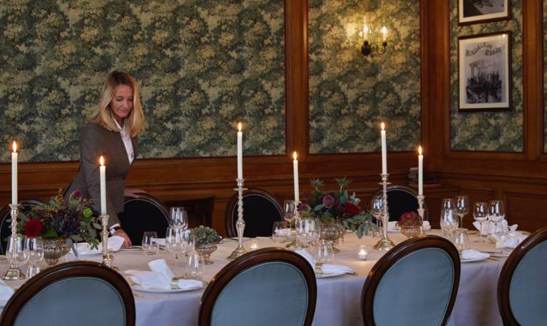 A host lays silverware on a table in the billiard room at Gleneagles
