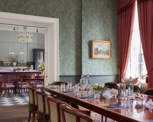 The broadcasting room set for a board meeting with open doors showing the pantry