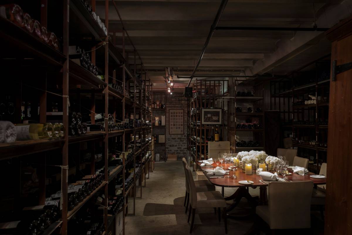 The cellars set up dfor a private dinner for 8 with wine racks surrounding it