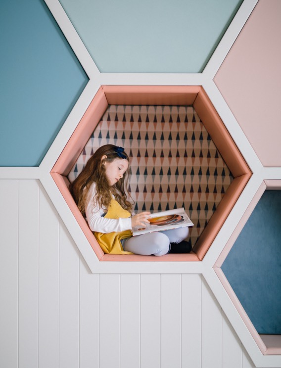 A girl sat reading in the Den