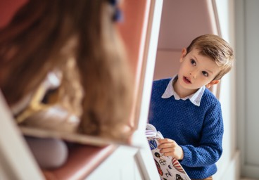 Two children in hexagonal cubby holes chat to each other