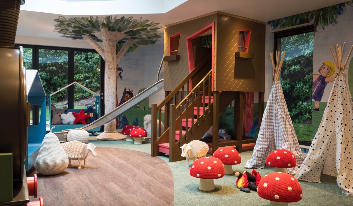 A treehouse climbing frame, teepees, mushroom shaped stools and wooden toys in Little Glen