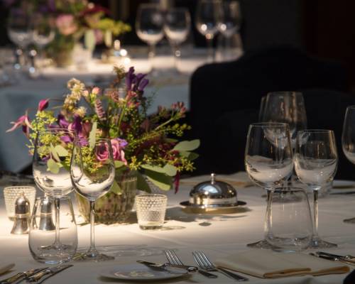 Silver service set out on dinner tables in the Henry hall