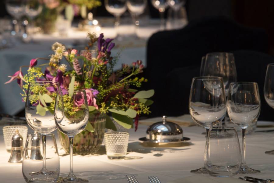 Silver service set out on dinner tables in the Henry hall