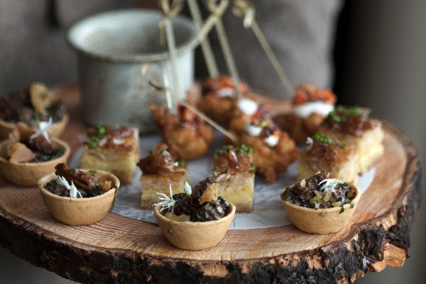 A selection of canapés on a cut wood platter