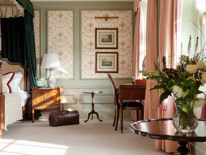 a leather holdall sots next to a four poster bed in the royal lochnagar suite