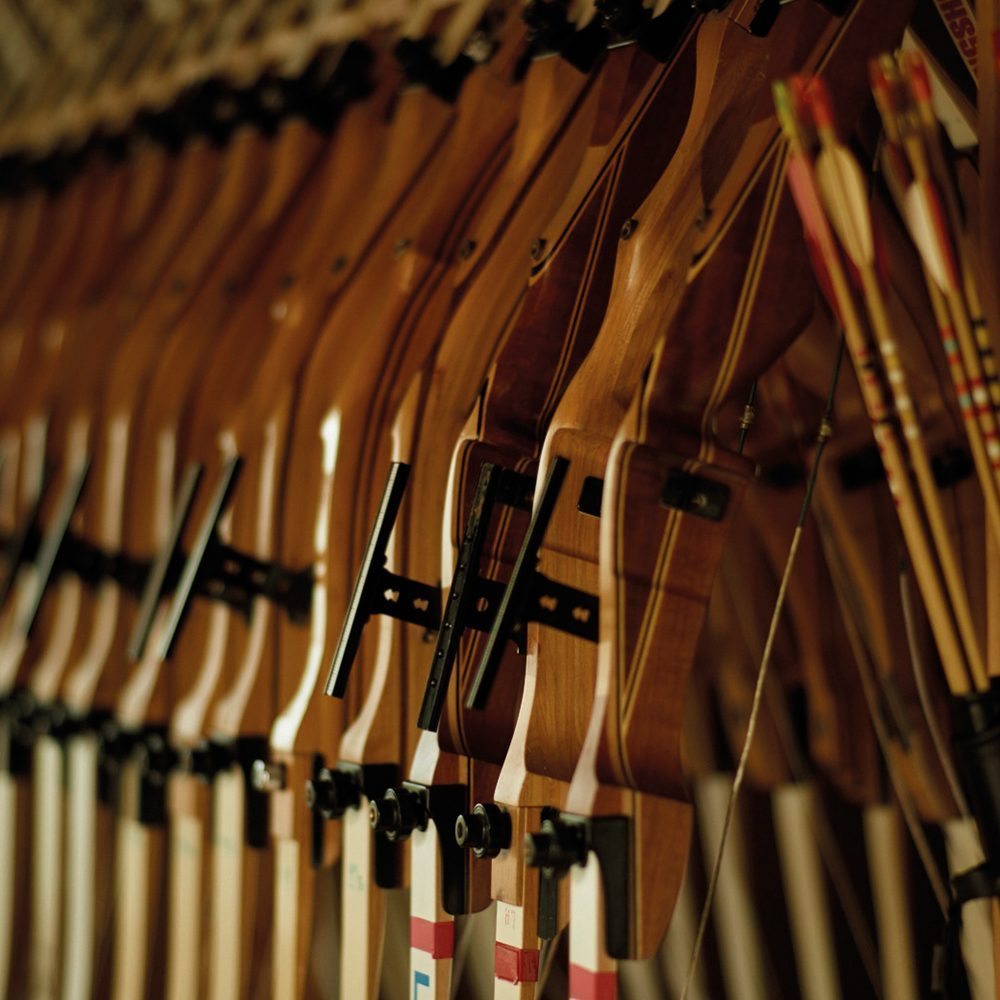 A row of archer's bows lined up in the shooting school